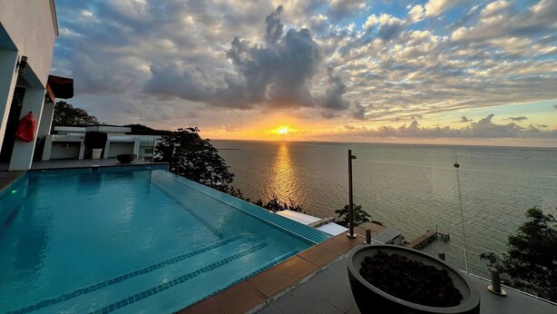 A swimming pool with a sunset view over the water. - NEW! Oceanfront Lux Villa w/ Private Infinity Pool, King Suites, Dock to Ocean (Punta Blanca)