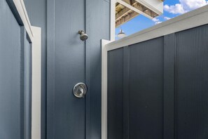 A dark wooden door with a metal handle and a peephole. - Modern 3BR Galveston with Fire Pit & Private Pool & Jacuzzi | Mins to the Beach (Galveston)