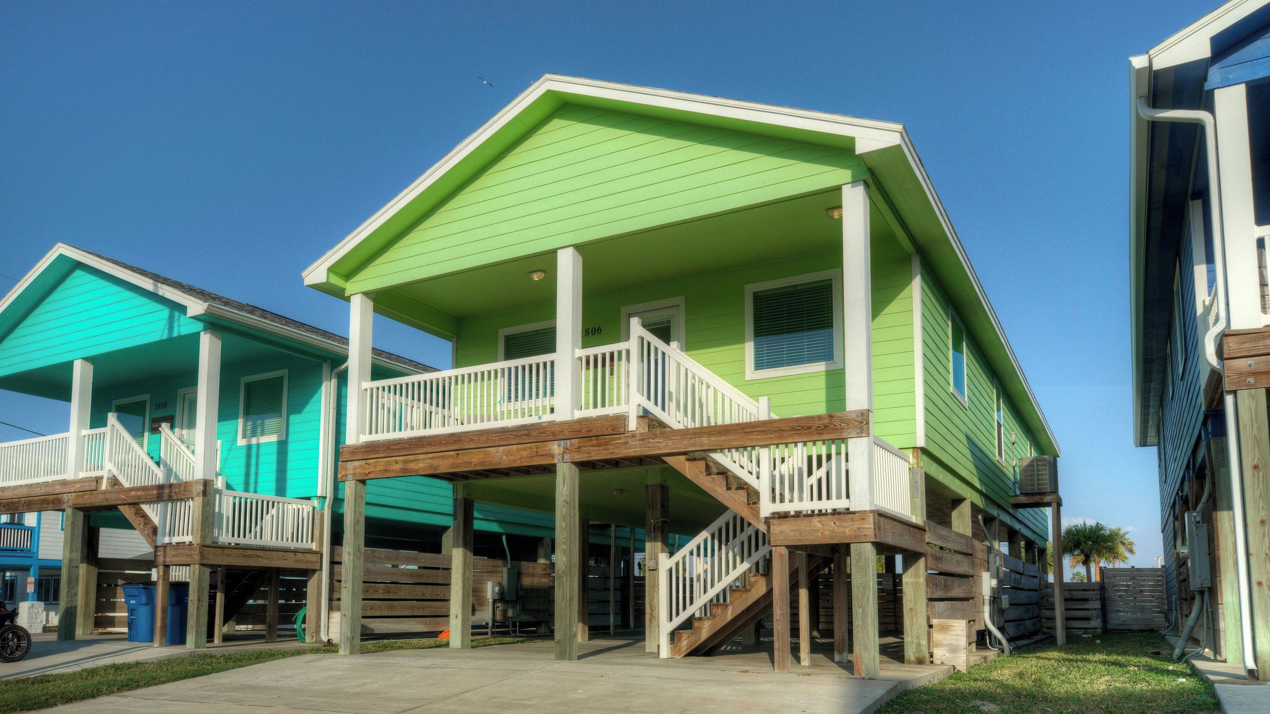 A row of two-story houses with a wooden deck and white railings.