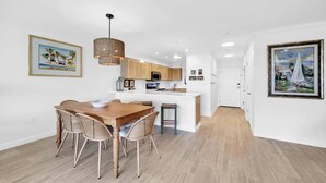 Una cocina moderna con armarios de madera, una isla central e iluminación colgante.