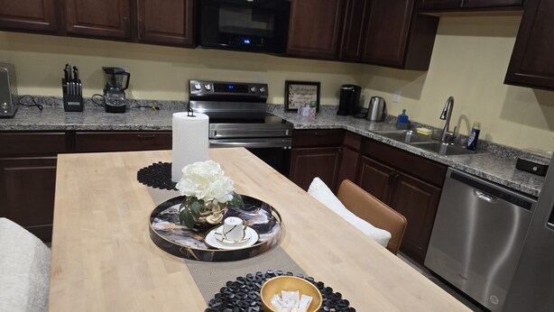 A kitchen with wooden cabinets, a microwave, a coffee maker, and a dishwasher.