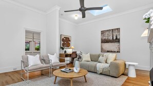 Ein modernes Wohnzimmer mit einer Couch, einem Couchtisch, einem Beistelltisch und einem Bild an der Wand.