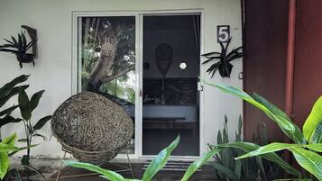 A covered porch with a thatched roof, a sliding glass door, and a number '5' sign.