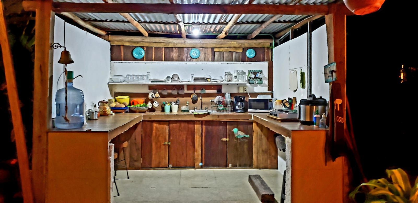 Une cuisine de taille réduite, dotée de meubles de rangement en bois, d’un plan de travail et de divers appareils de cuisine.