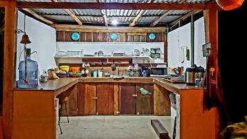 Une cuisine de taille réduite, dotée de meubles de rangement en bois, d’un plan de travail et de divers appareils de cuisine.