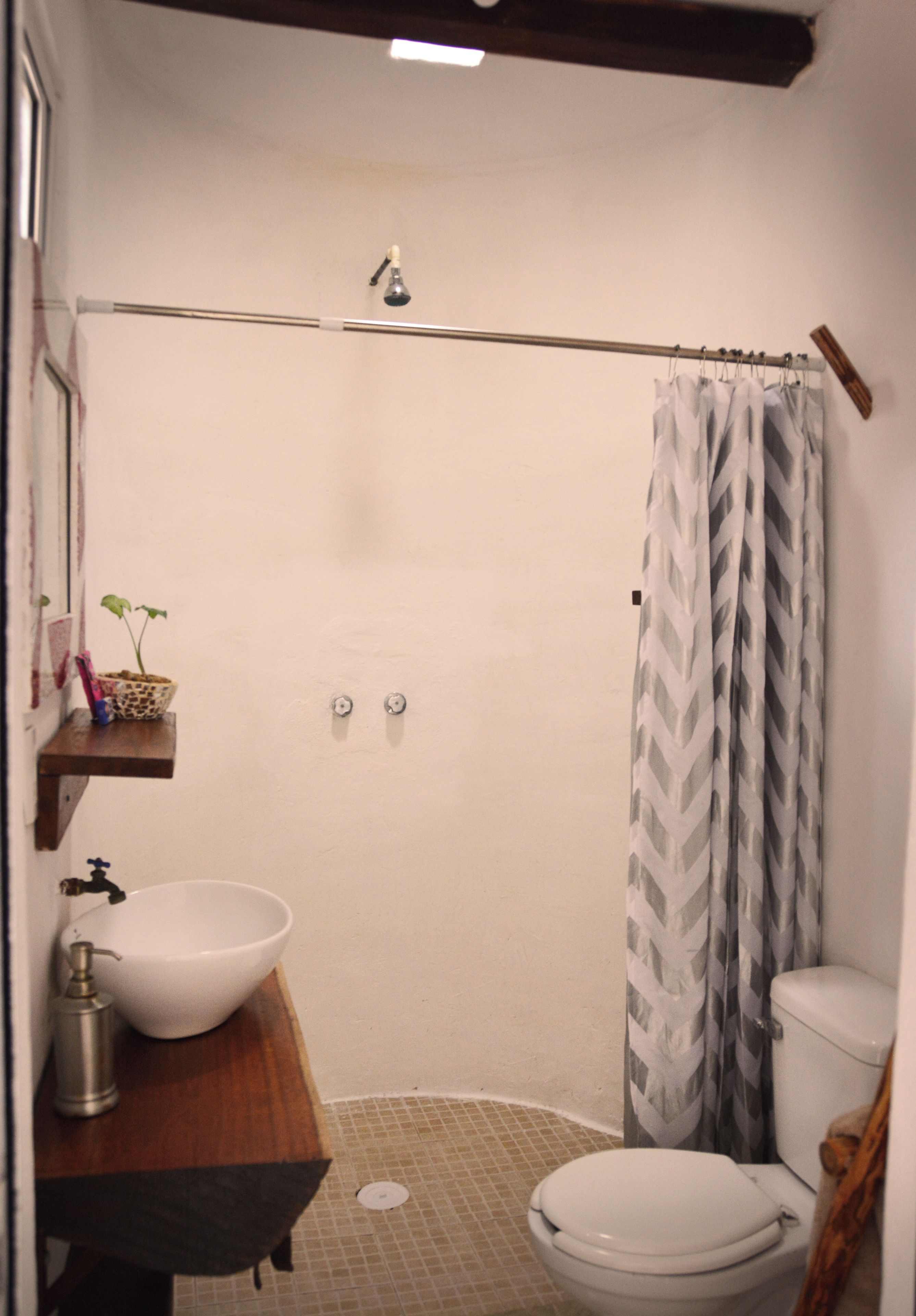Un baño pequeño con ducha, inodoro y lavabo.