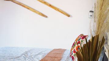 A bed with a patterned bedspread, a brown blanket, and a decorative pillow.