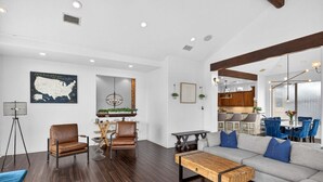 A modern living room with a sofa, chairs, a coffee table, and a map on the wall.