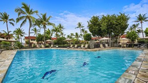 A swimming pool with clear blue water, surrounded by palm trees and lounge chairs. - Surf & Racquet 3-301 Oceanfront 3BR Penthouse | Views, Lanai, AC (Kailua Kona)