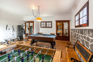 A room with a foosball table, a pool table, exercise equipment, and a stone wall. - Bellavista private heated pool and sauna (Valles, Los)