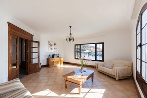A spacious living room with a wooden coffee table, a beige sofa, and a large window offering a view of the outdoors. - Bellavista private heated pool and sauna (Valles, Los)
