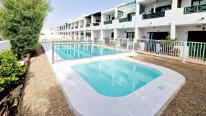 Un hôtel doté d’une piscine, de plusieurs balcons et offrant une vue sur un ciel dégagé.
