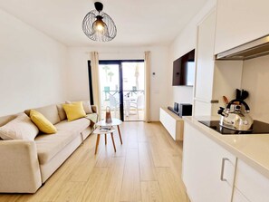 A modern living room with a sofa, a small table, a kettle, and a TV. - Casa Marisa in Puerto del Carmen (Puerto Del Carmen)