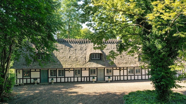 A traditional thatched-roof building with a gravel driveway and surrounding greenery. - VillaVilla 951 - Nr. Aaby, Fyn og øer (Nørre Aaby)