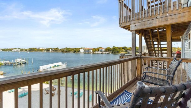 A wooden deck with chairs overlooking a marina. - New! Bayfront Condo w/ 2 Balconies, Loft & Pool – Walk to Beach (Fort Walton Beach)