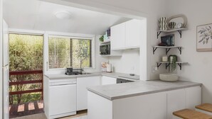 Une cuisine moderne avec des meubles blancs, un four à micro-ondes encastré et un grand îlot central.