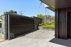 Ein verschlossenes Tor mit einem Betonweg, der zu einem Gebäude führt.