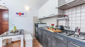 Eine moderne Küche mit weißen Schränken, einer schwarzen Arbeitsplatte und einem Gasherd.
