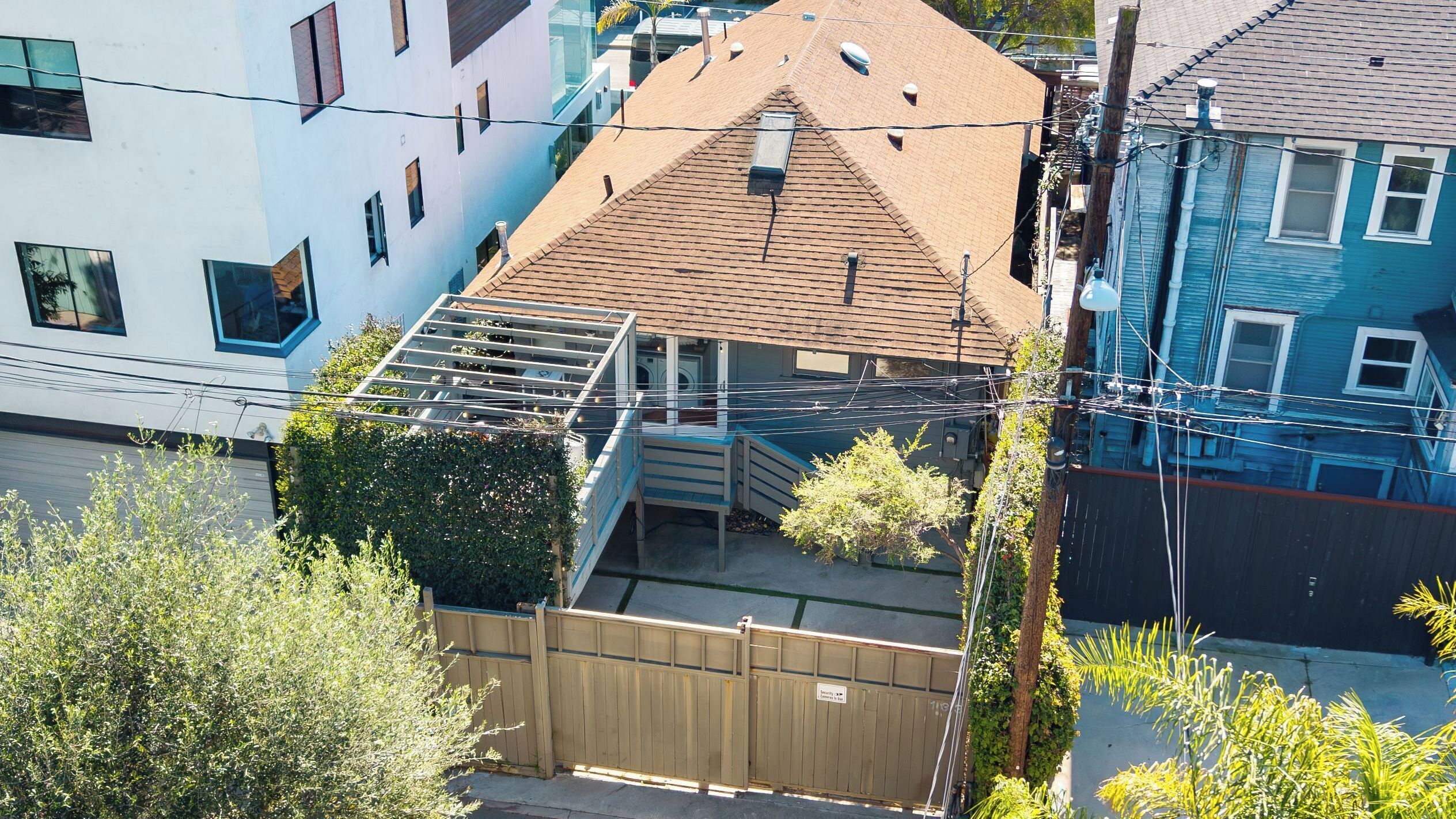 Un edificio residencial con techo inclinado, una escalera visible que conduce a un nivel superior y una entrada con reja.
