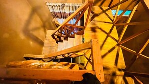 A wooden staircase leading to a room with a view of the outside. - Ama Eco Lodge (WPRH+9G Sigiriya)