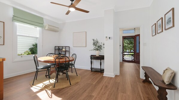 A dining area with a round table, chairs, a ceiling fan, and a view through an open door. - Audrey's Of Beechworth NEW Listing (Beechworth)