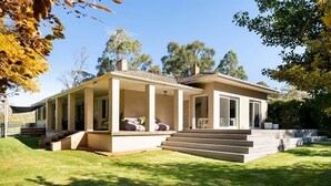 A two-story house with a covered porch, a front yard, and a staircase leading to the entrance. - Clare Valley vineyard - Pool and walk to wineries - perfect for groups (Sevenhill)