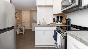 Una cocina moderna con armarios blancos, electrodomésticos de acero inoxidable y una isla de madera.