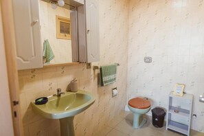 A bathroom with a sink, toilet, and cabinet. - IKE Hospedagem Uruguaiana (Uruguaiana)