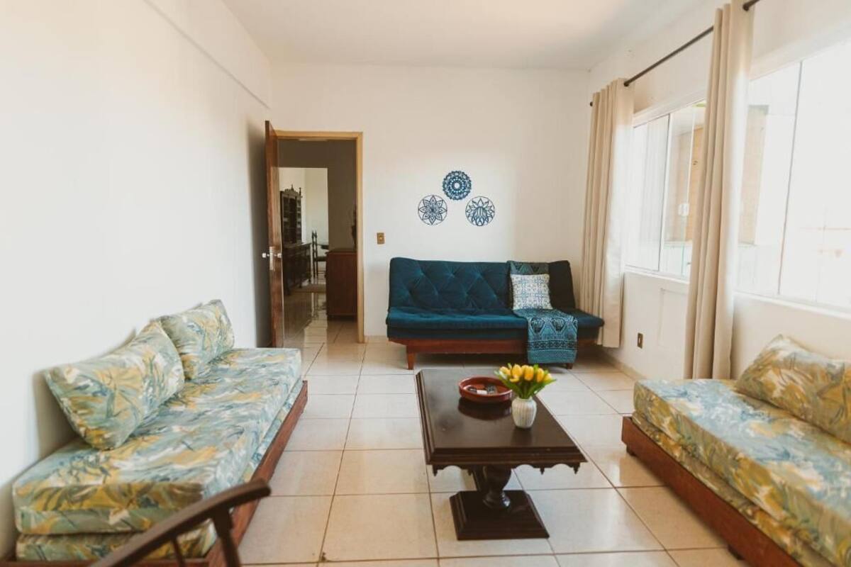 Ein Wohnzimmer mit einer Couch, einem Couchtisch mit einer Vase und einer Wand mit dekorativen Mustern.