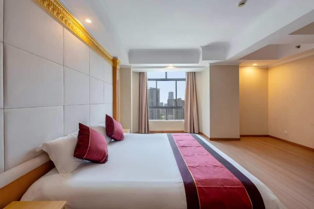 Une chambre d’hôtel dotée d’un grand lit, offrant une vue sur la ville et présentant un design moderne.
