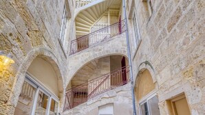 A multi-level stone building with balconies, arched doorways, and a spiral staircase. - A superb large loft in the heart of Bordeaux (Bordeaux)