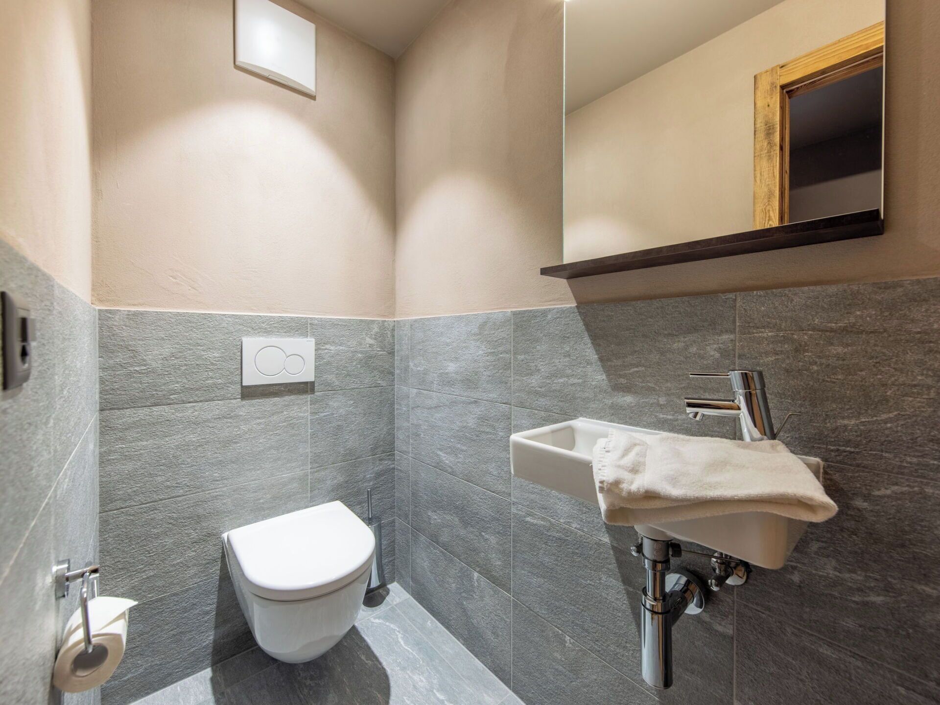 Un baño en esquina con inodoro, lavabo y espejo.