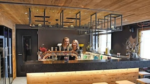 A bar area with a wooden ceiling, bar stools, and a counter with taps. - Cosy apartment for 6 guests with WIFI, TV and pets allowed (Zinal)