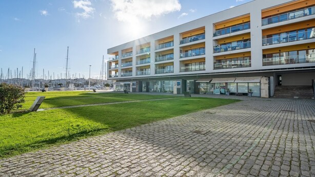 Un edificio moderno a più piani con tetto piatto, ampie finestre e balconi.