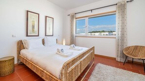 Una camera da letto con un letto, una finestra vista, una sedia e un tavolino.
