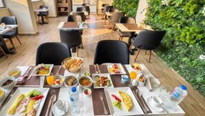 Un comedor con varias mesas, sillas y una gran variedad de alimentos.