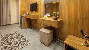 Un baño moderno con paneles de madera, un tocador con espejo, un lavamanos, un inodoro y una pequeña estatua sobre la encimera.