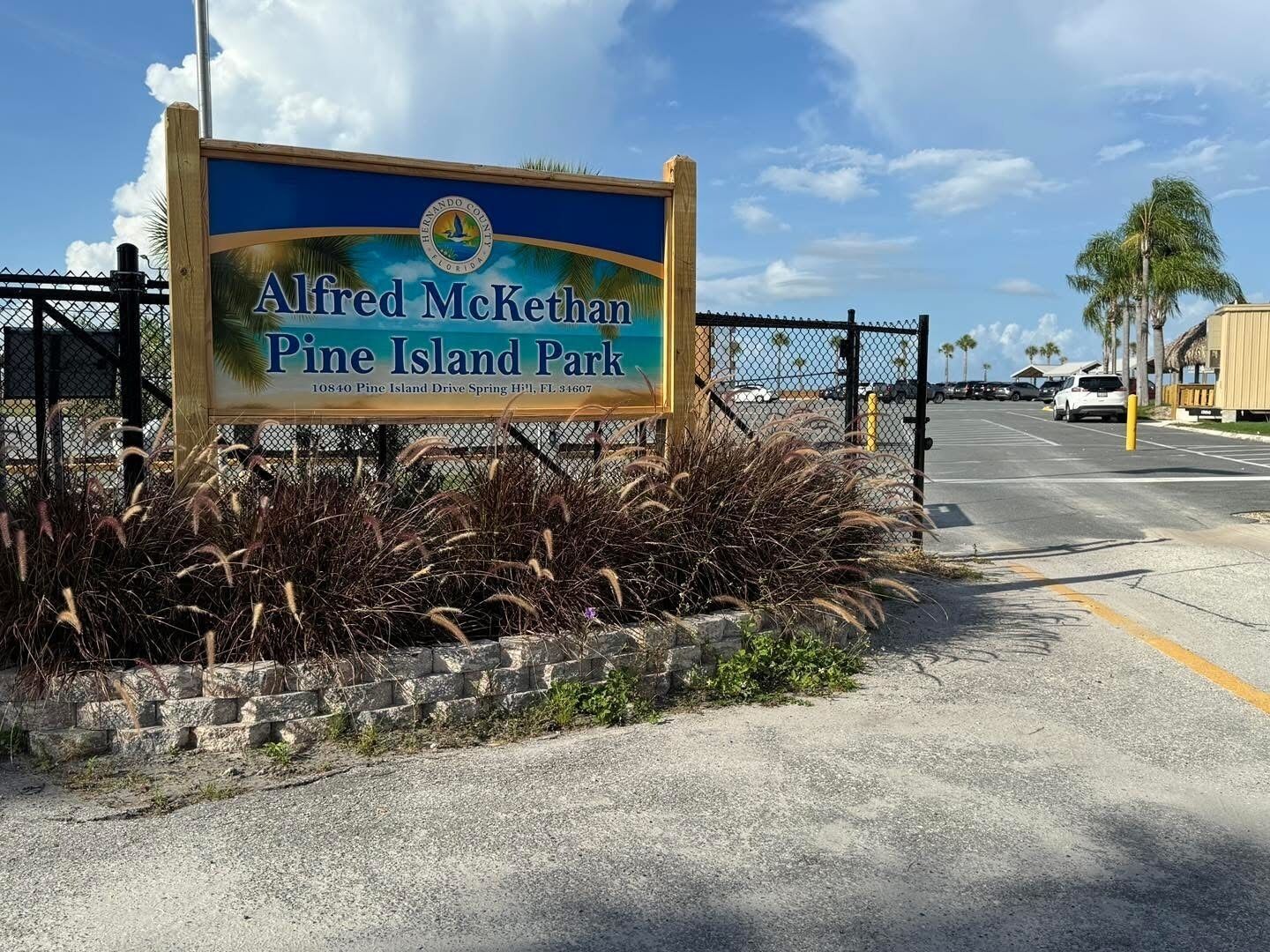 A sign for Alfred McKethan Pine Island Park with a clear view of the surrounding area.