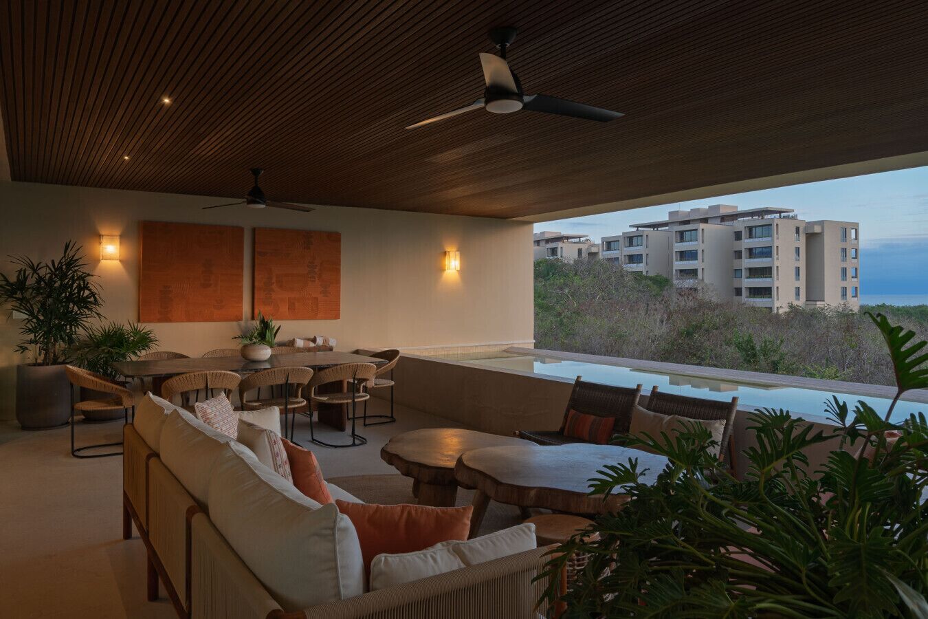 Eine moderne Lounge im Freien mit Deckenventilator, Esstisch und bequemen Sitzgelegenheiten.