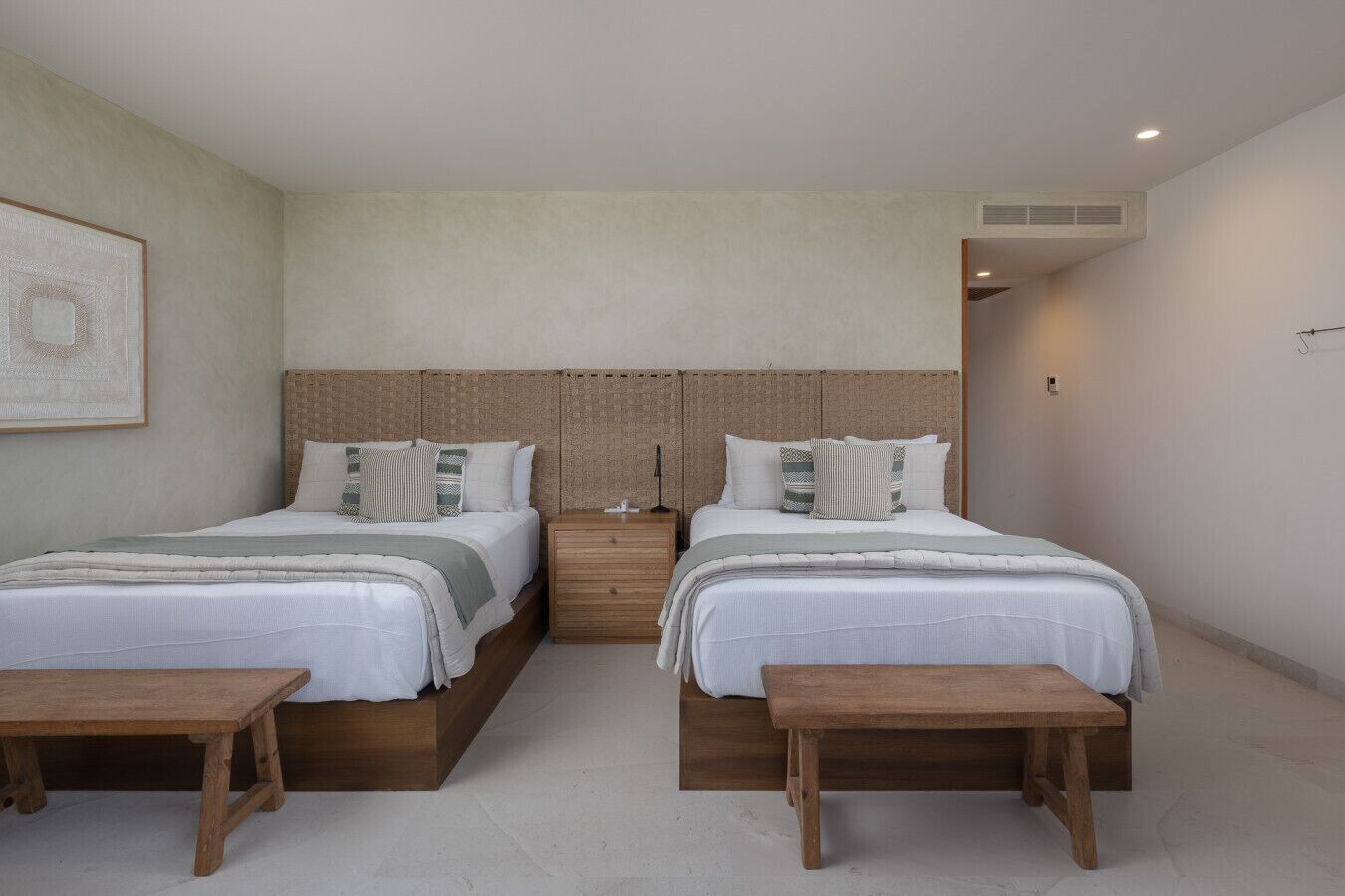 Ein Doppelzimmer mit Bett, Nachttischen und einer Bank.