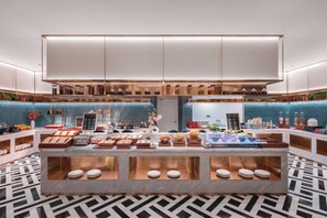 A modern buffet setup with a variety of food items and a marble counter. - Madison ShenzhenScienceandTechnologyPark (Shenzhen)