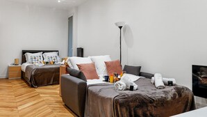 Une chambre d’hôtel moderne avec deux lits, une table de chevet, une lampe et un panneau d’accueil encadré.