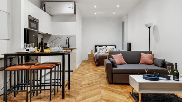 Un appartement moderne comprenant une cuisine, un coin repas et un salon.