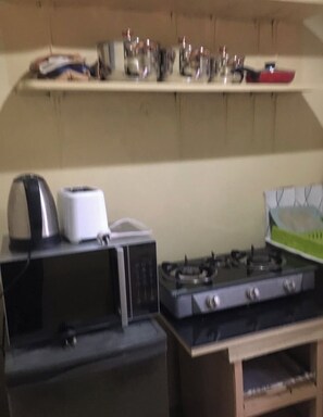 A kitchen with a microwave, toaster, and gas stove. - 2BR 1BA apartment near Kitintale Market Kampala with Wi-Fi, AC (Kampala)