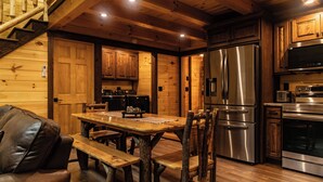 Un intérieur en bois comprenant une table à manger, des chaises, un canapé et des appareils de cuisine.