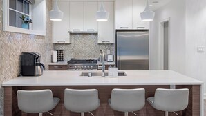 A modern kitchen with a large island, stainless steel appliances, and pendant lighting. - Kitsilano Retreat: Private 3-Bed w/ Parking & BBQ (Vancouver)