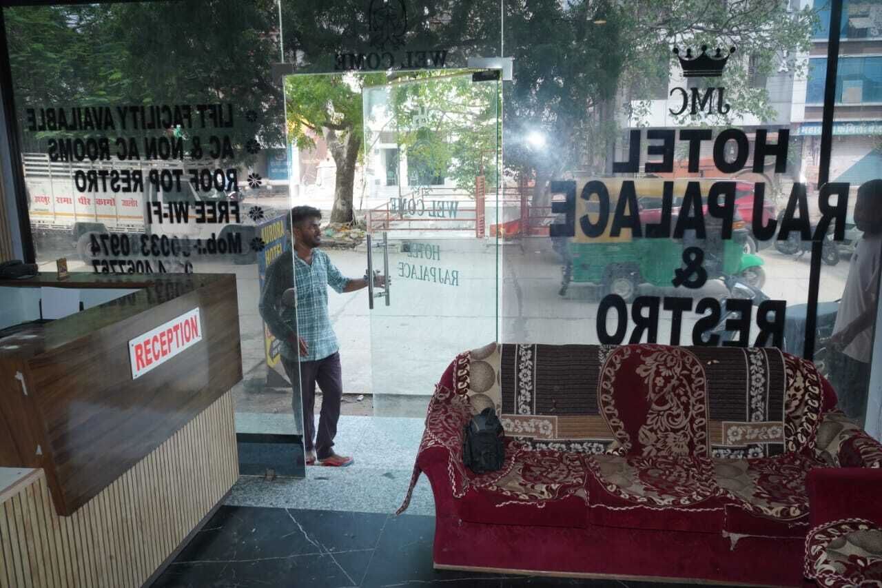 A reception desk with a sign labeled 'RECEPTION' and a sofa with a patterned cover.