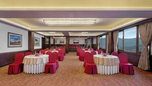 A conference room with round tables, red chairs, and a carpeted floor. - Welcomhotel By ITC Hotel Denzong Regency (Gangtok)