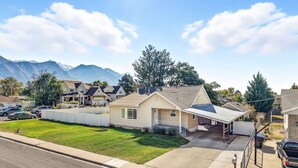 Ein Wohnhaus mit Garage, überdachter Veranda und Auffahrt.