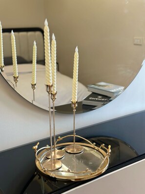 A reflective surface with candles and a tray.